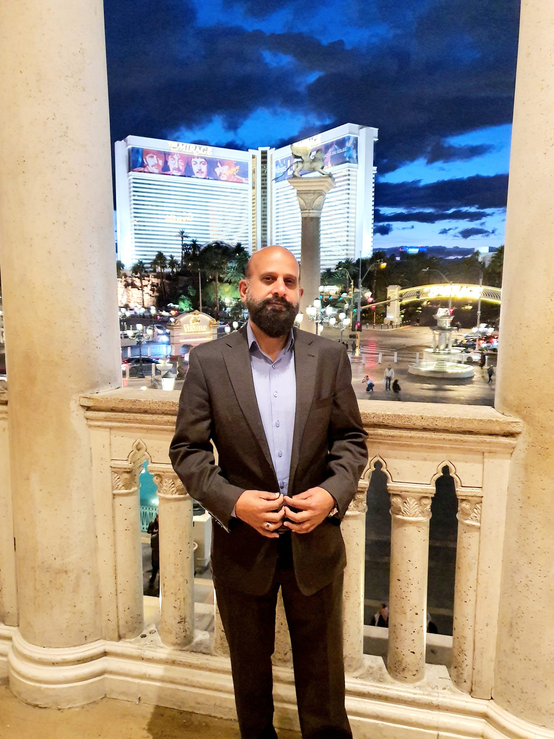 Dr. M Nadeem Ashraf, UK-trained doctor and life coach, standing in professional attire